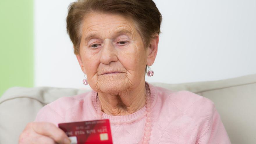Seniorin schaut sich ihre Krankenkasse Versichertenkarte an