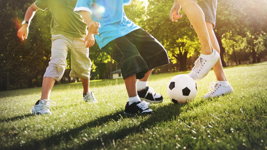 Jungen spielen Fußball auf der Wiese