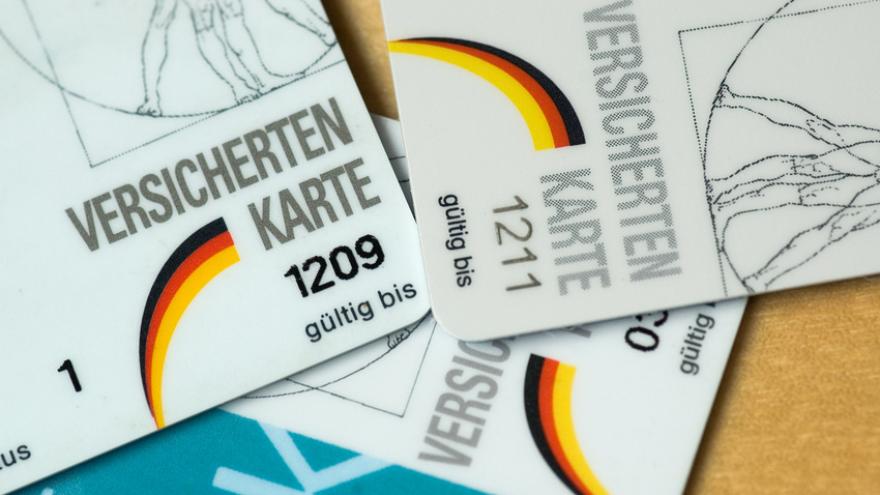 Verschiedene Krankenkassen Versichertenkarten liegen auf einem Haufen